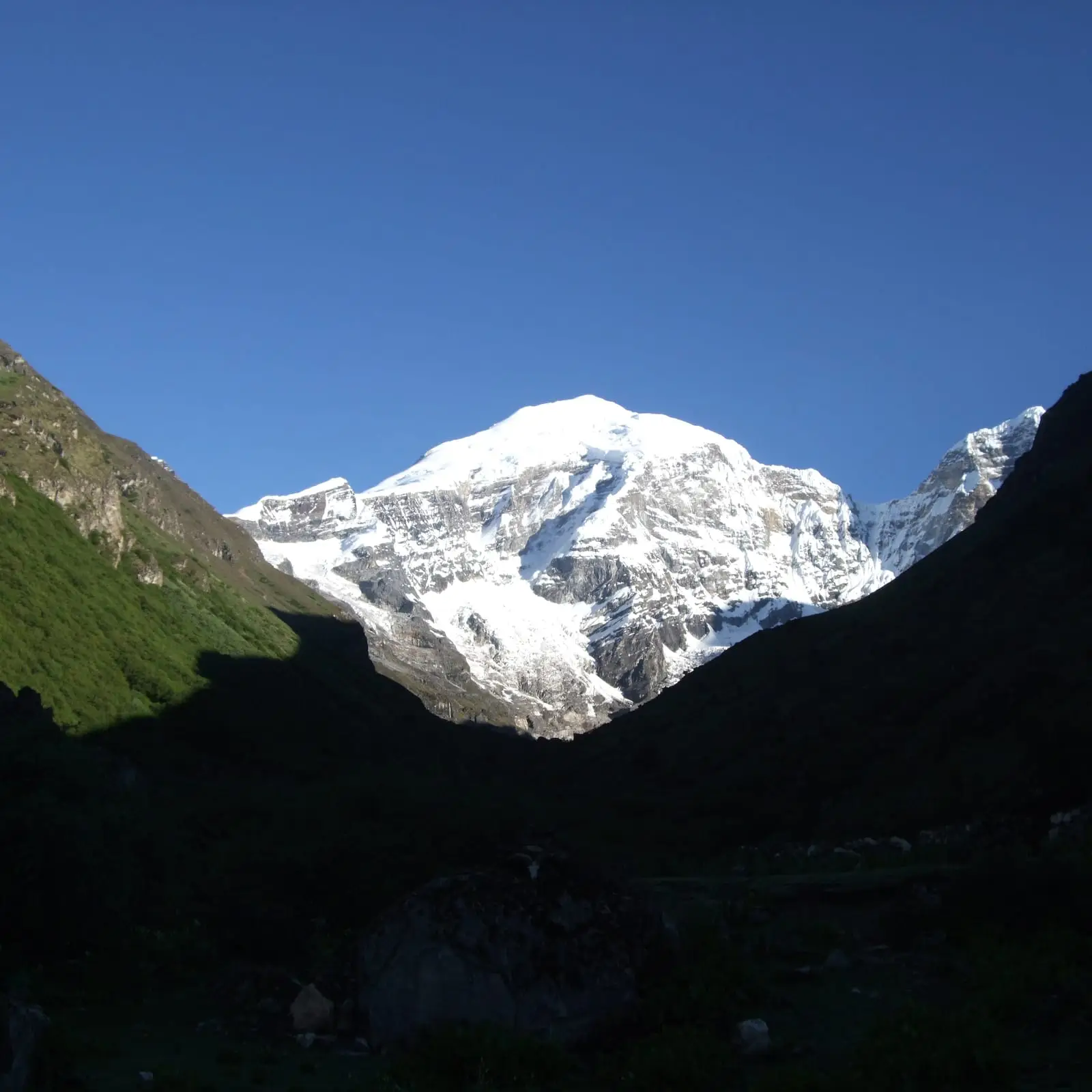 Morning sun on Mount Jomolhari at the head of a shadowed valley