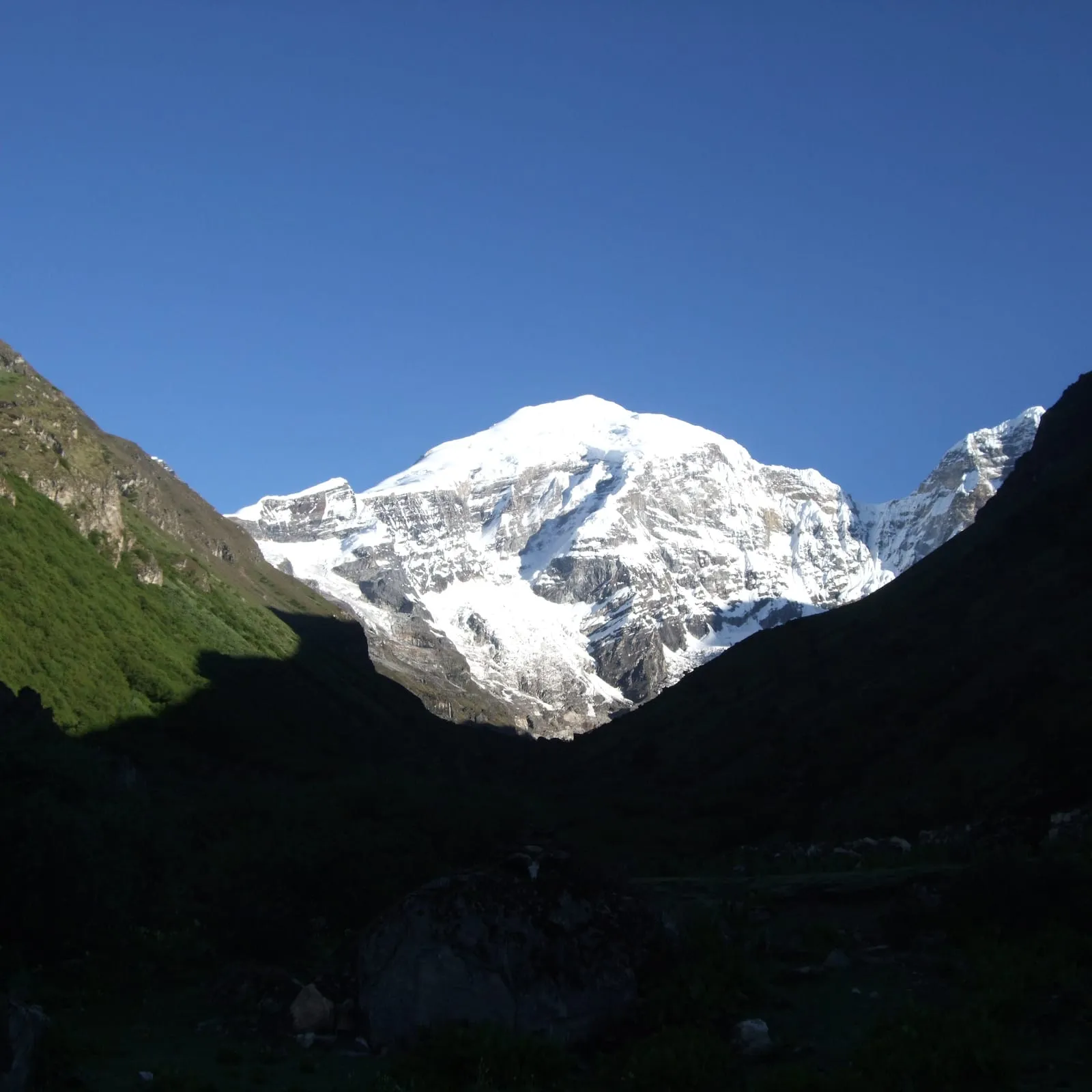 Morning sun on Mount Jomolhari at the head of a shadowed valley