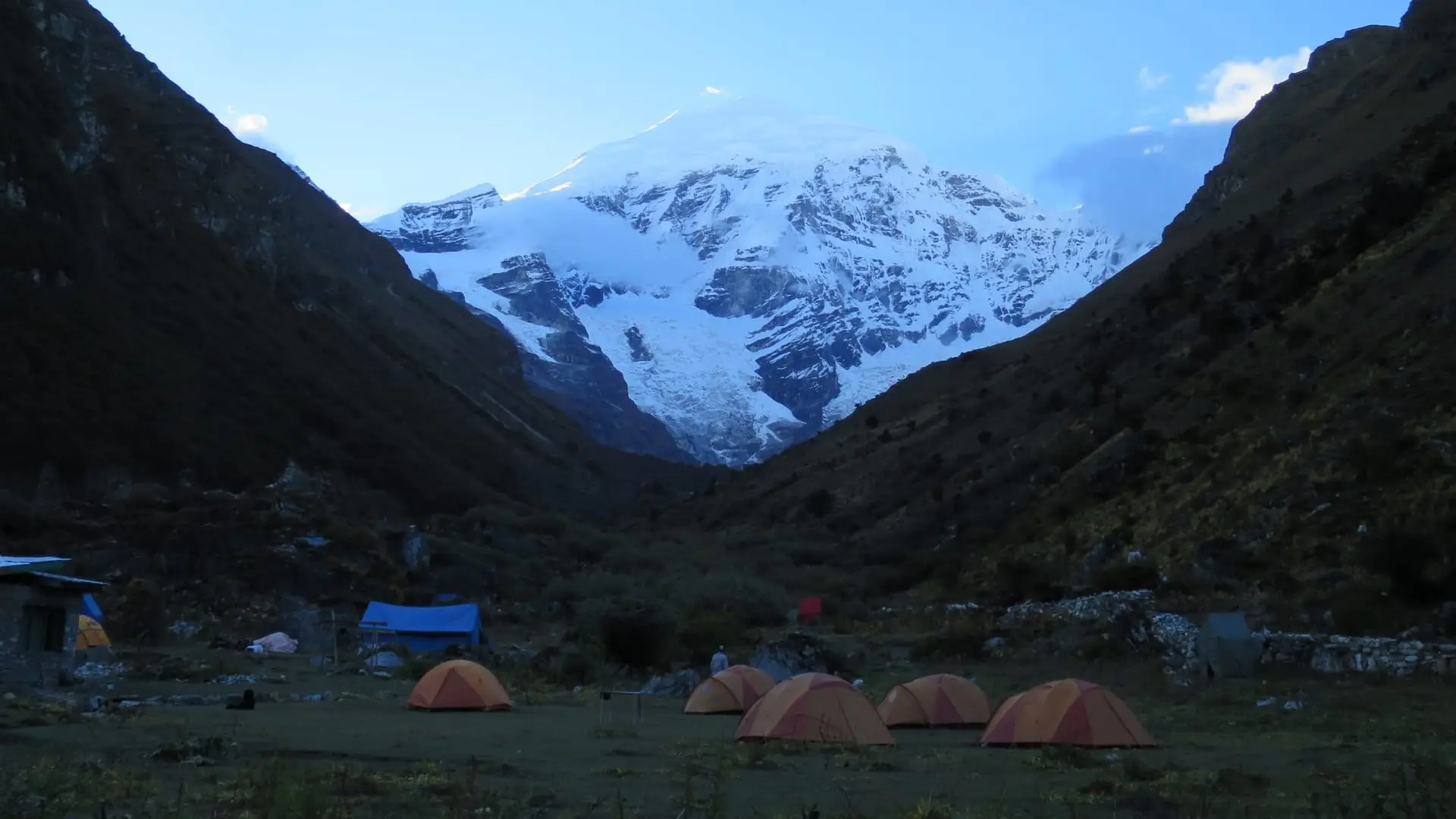 Tents at Jangothang base camp at dusk beneath the snow face of Mount Jomolhari